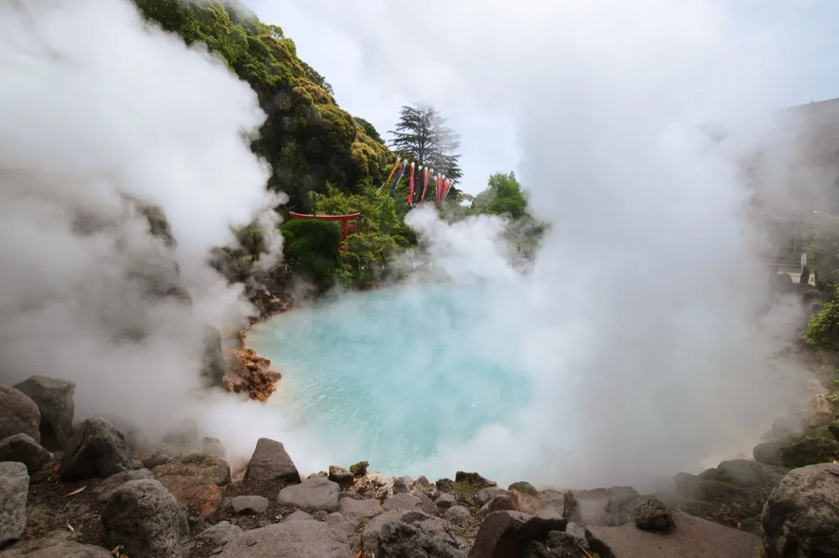 Steaming turquoise hot spring with a torii in Hakone