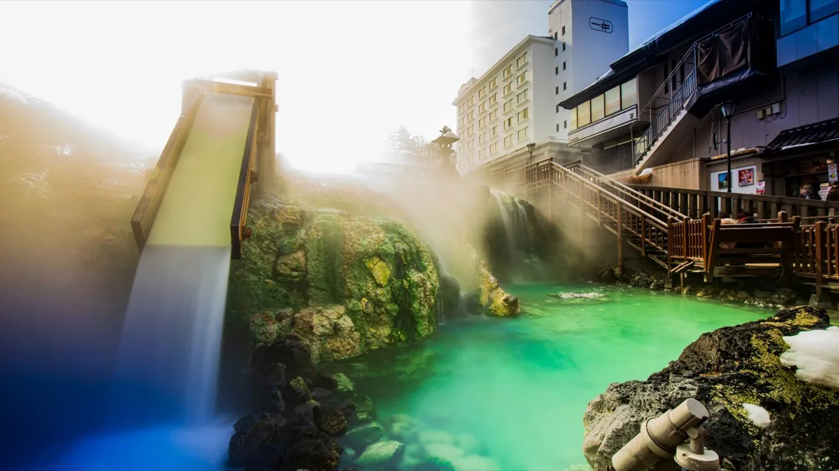Green thermal waters and wooden cooling ramp of the Yubatake in Kusatsu